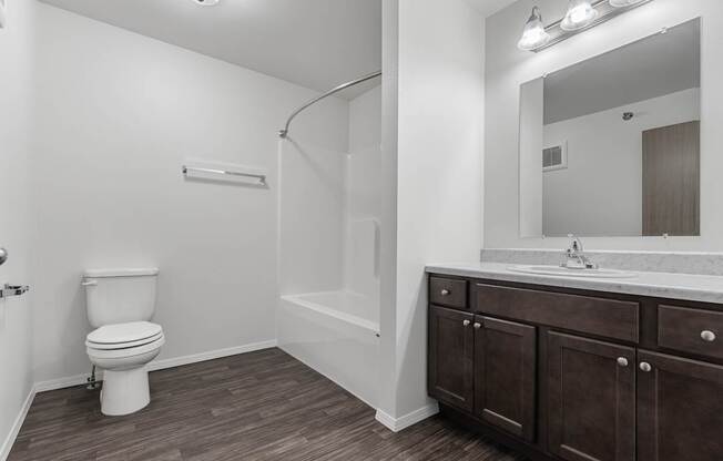 A white toilet is in a bathroom with brown cabinets.