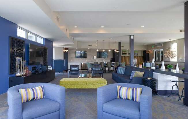 a lobby with blue couches and chairs with a yellow couch in the middle of the room
