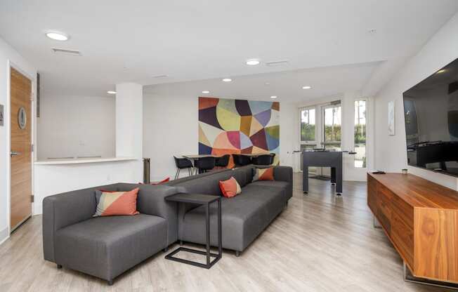 a living room with a gray couch and a dining room table