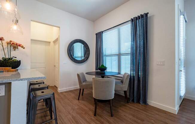 A dining room with a table and chairs.