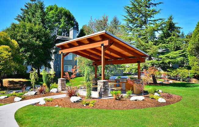 an outdoor kitchen with a wooden awning and stone pillars