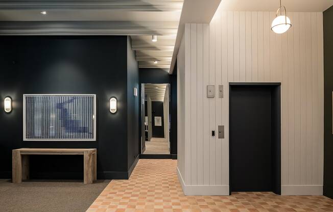 a hallway with black walls and a checkered tile floor and a black door