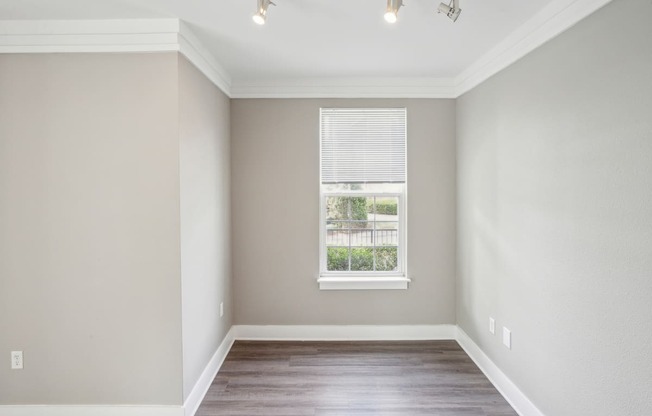 an empty room with wood floors and a window