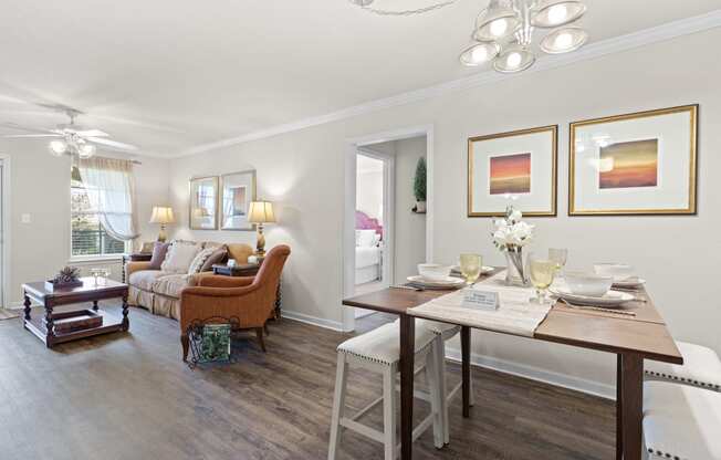 a living and dining room area with a wooden table and chairs and a couch in the background