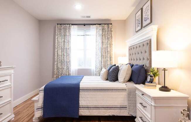 A bedroom with a white bed and blue bedspread.
