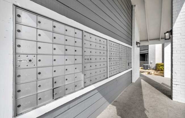 the lockers in the hallway of the building are white and stainless steel