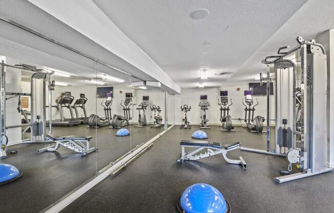 a fitness room with weights and cardio equipment at the grove apartments