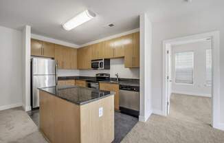 A kitchen with a refrigerator, microwave, and oven.