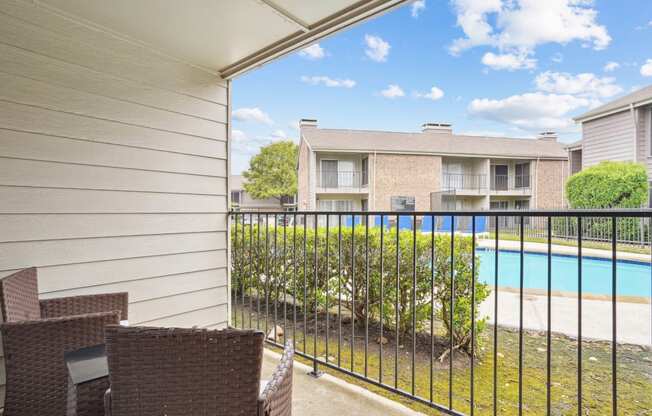 Model A2 floor plan balcony with chairs and view of the pool Noel on The Parkway in Dallas, TX