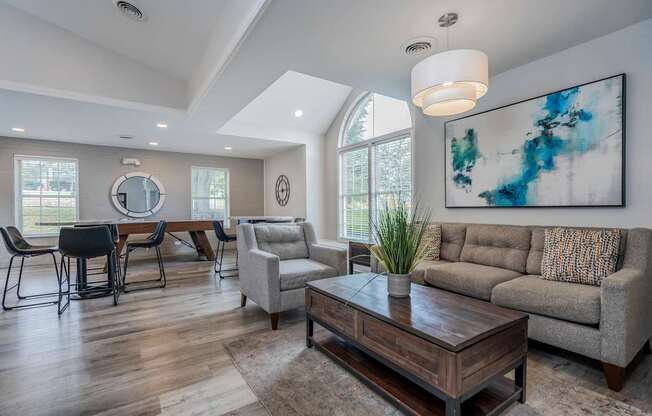 A modern living room with a large painting on the wall.