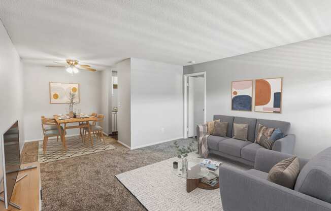a living room with a couch a table and a ceiling fan