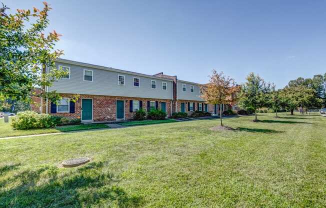 a large yard in front of a brick apartment building
