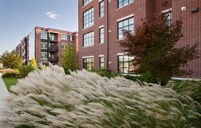 a fountain of grass in front of a brick building  at The Sheffield Englewood, Englewood, NJ, 07631