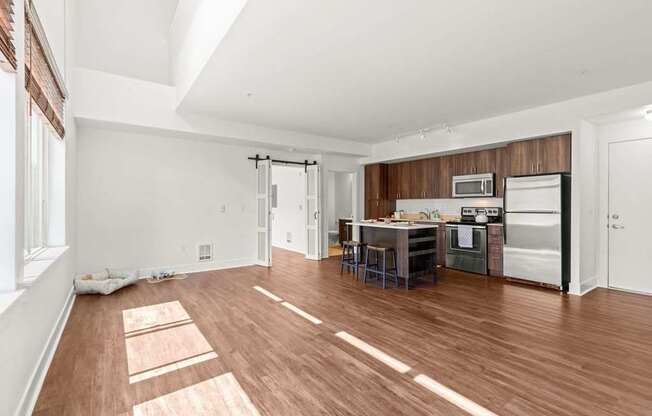 A kitchen with white walls and wooden floors.