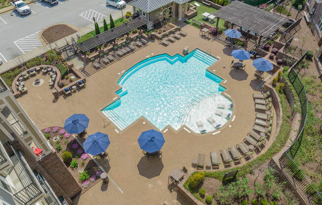 a large swimming pool with lounge chairs and umbrellas
