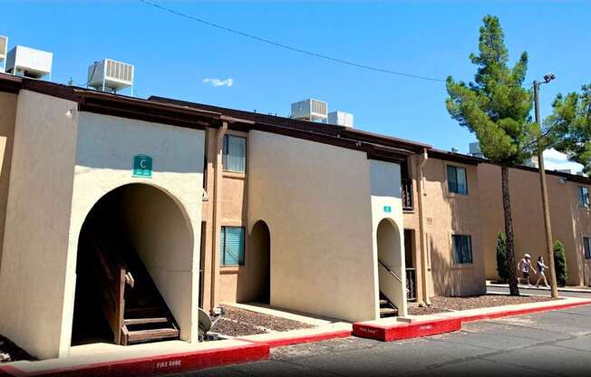 A row of beige buildings with arched doorways and windows.