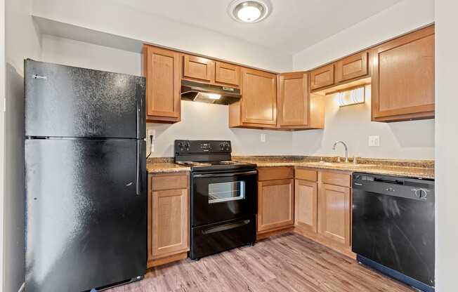 A kitchen with black appliances and wooden cabinets.