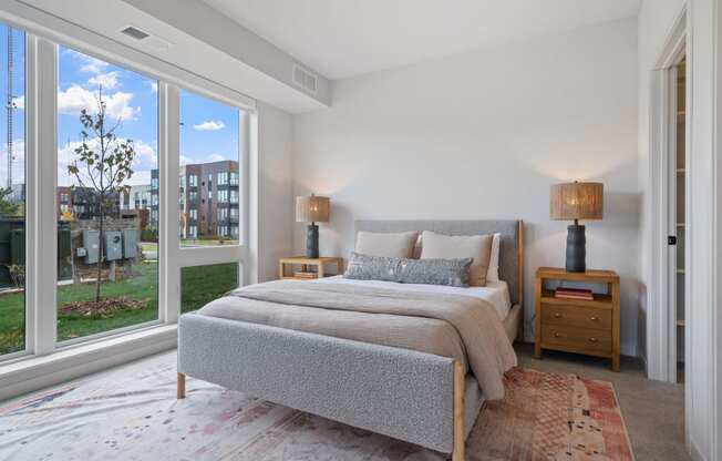 a bedroom with a bed and a large window