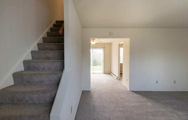 This is a photo of the living room and stairway in the 1004 square foot, 2 bedroom, 1.5 bath townhome floor plan at Lake of the Woods Apartments in Cincinnati, OH.