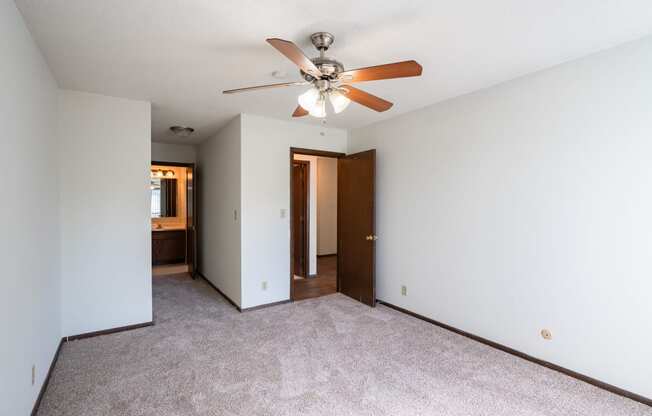 a bedroom with a ceiling fan and white walls. Eagan, MN Glen Pond Apartments