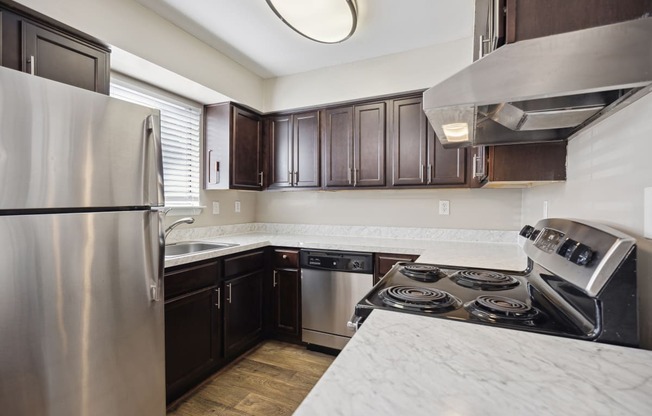 an updated kitchen with stainless steel appliances and marble counter tops
