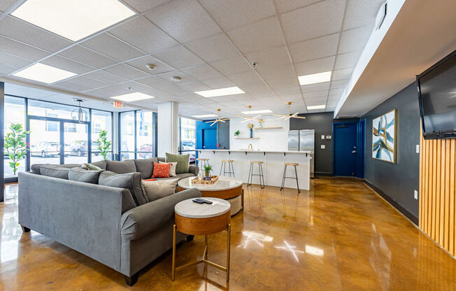 a living room with couches and a kitchen in the background