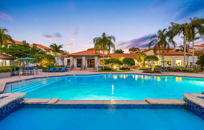A swimming pool surrounded by palm trees and a house.