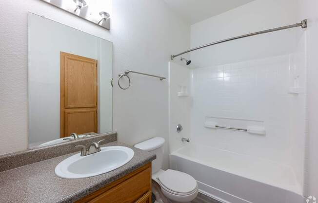 A bathroom with a sink, toilet, and bathtub.