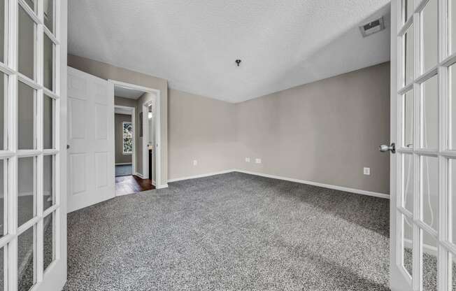 the living room of an empty house with white doors