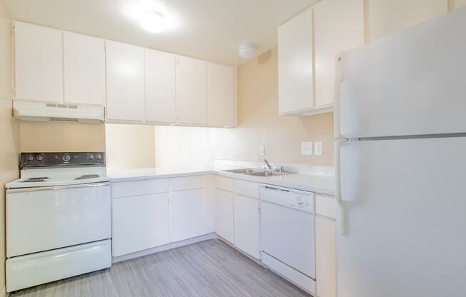 a white kitchen with white appliances and white cabinets