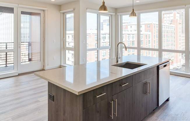 A modern kitchen with a large island and wooden cabinets.