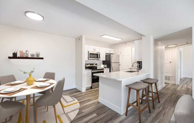 A modern kitchen with a dining table set for four.