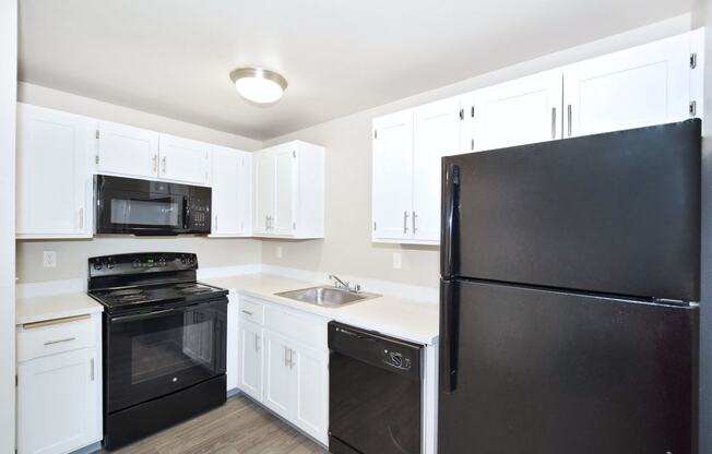 a kitchen with black appliances and white cabinets