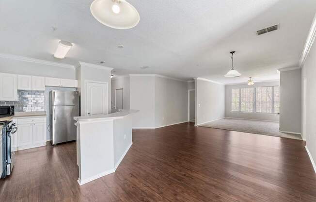 A kitchen with white cabinets and a refrigerator.