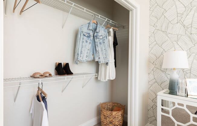 a closet with clothes hanging on the wall and a closet door with shoes on it