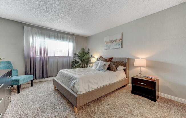 a bedroom with a bed and a dresser and a window t Desert Bay Apartments, Laughlin, NV