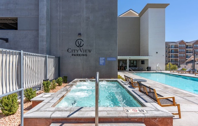 a swimming pool in front of a cityview parking building