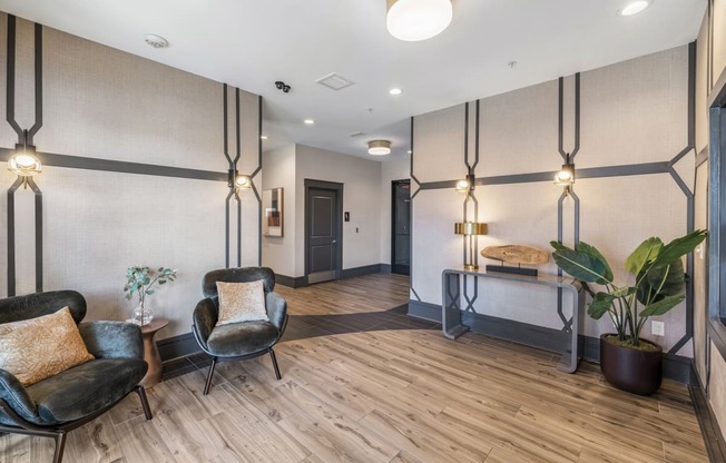 a lobby with chairs and a table with a plant