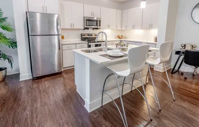 a kitchen with a island and a stainless steel refrigerator
