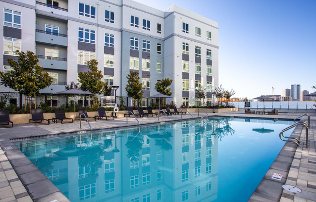 a large swimming pool in front of an apartment building