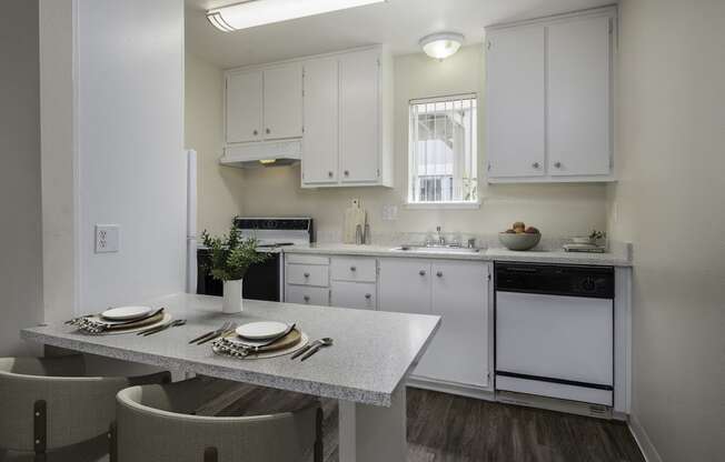 a kitchen with white cabinets and a table and chairs