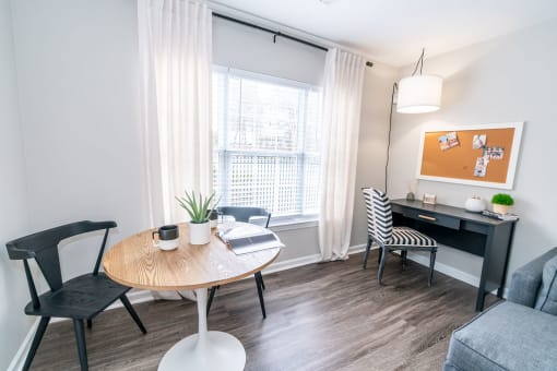 a living room with a table and chairs and a window at Merion Milford Apartment Homes, Milford, 06460