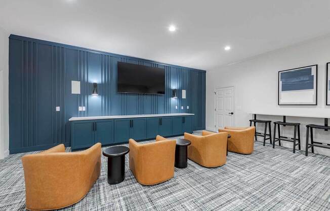 A room with a bar and orange chairs.