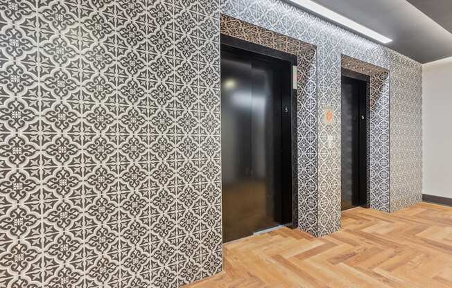 a corridor with two doors and a wooden floor and a patterned wall paper at Rialto, Washington