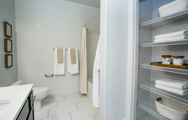 A white bathroom with a toilet, sink, and towels.
