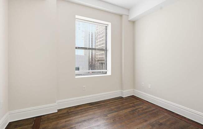 A room with a window and wooden floors.