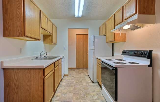 a kitchen with white appliances. Fargo, ND Dakota Manor Apartments