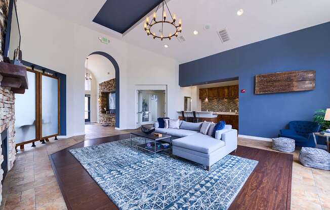 A living room with a white couch and a blue rug.