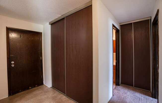 a closet with two doors and a door to a bathroom. Coon Rapids, MN Robinwood Apartments