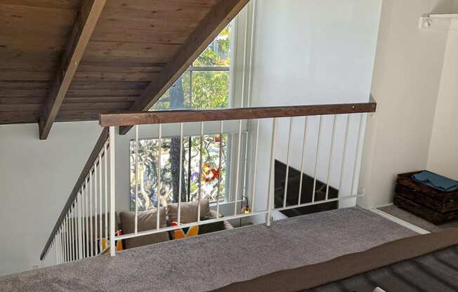 a bedroom with a bed and a staircase with a window